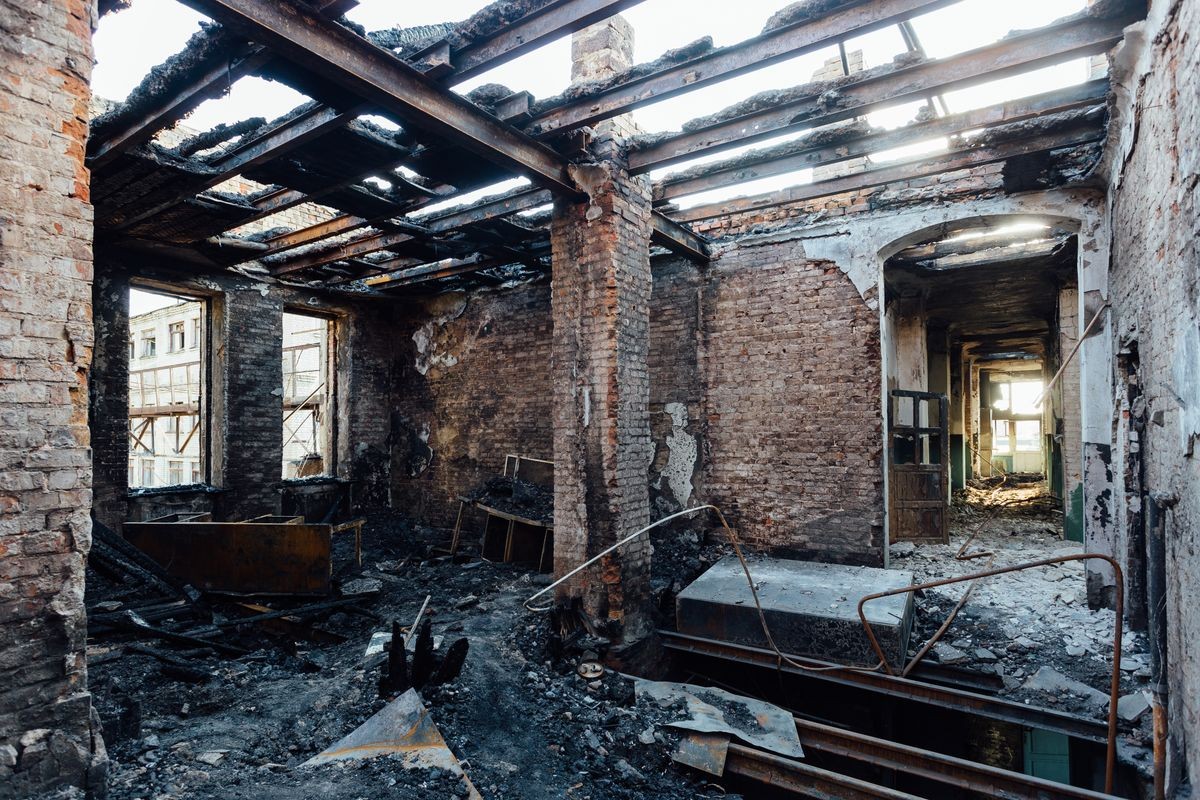 Burned interiors after fire in industrial or office building. Burnt furniture, failed roof